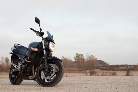 One black motorcycle in the desert in the fall.の写真素材