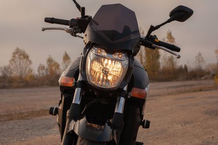 One black motorcycle in the desert in the fall.