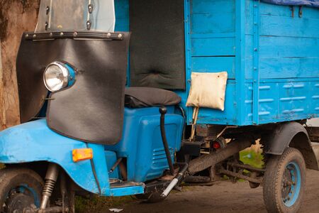Unusual old tricycle rides on the road.の写真素材