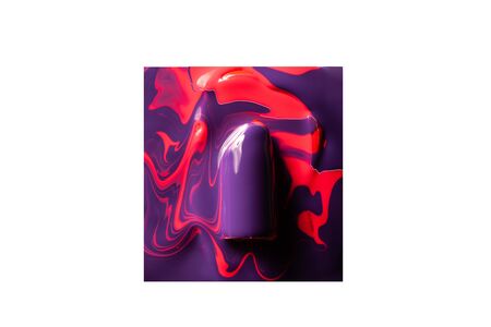 Violet lipstick in red paint on a white background.の写真素材