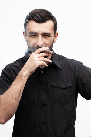 Handsome stylish man smokes a cigar.の写真素材