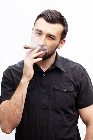Handsome stylish man smokes a cigar.の写真素材