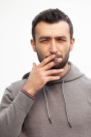 Handsome stylish man smokes a cigar.の写真素材