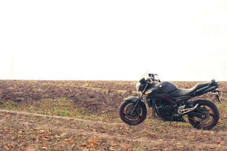 Black stylish sport motorcycle in autumn forest.のeditorial素材