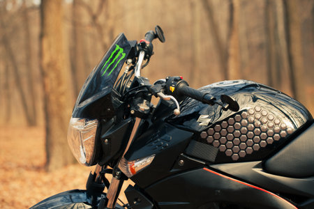 Black stylish sport motorcycle in autumn forest.のeditorial素材