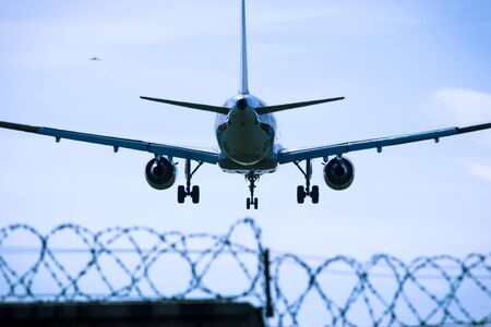 Jet airplane flying overhead close-up on a blue sky background