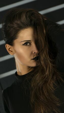 Beautiful femme fatale with bright makeup and black lipstick. Luxurious glamor portrait high fashion beauty model. Vogue Style Portrait on black backgroundの写真素材