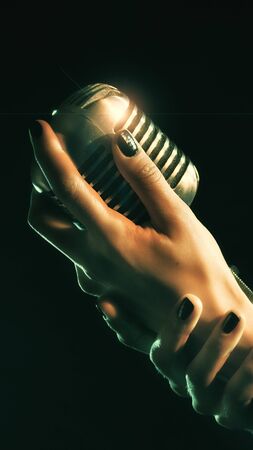 Close up of beautiful female woman singer mouth with red lips singing into a vintage microphone in a night clubの写真素材