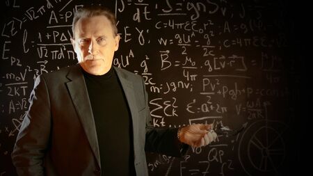 Medium shot of male university professor. Math formulas on blackboard. Knowledge and On-line...