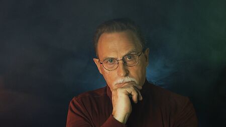 Mature gentleman on dark background. Medium shot portrait elderly elegant man. Handsome gray haired old businessman in glasses.の写真素材