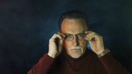 Mature gentleman on dark background. Medium shot portrait elderly elegant man. Handsome gray haired old businessman in glasses.の写真素材