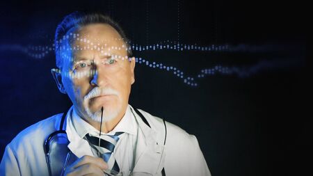 Mature doctor in white medical lab coat on dark background. Medium shot portrait elderly scientist in high tech laboratory. Handsome gray haired old doctor in mask looking at augmented reality screen.の写真素材