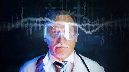 Mature doctor in white medical lab coat on dark background. Medium shot portrait elderly scientist in high tech laboratory. Handsome gray haired old doctor in mask looking at augmented reality screen.の写真素材