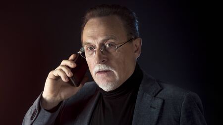 Mature gentleman talking on a smartphone. Medium shot portrait elderly elegant man with phone on...
