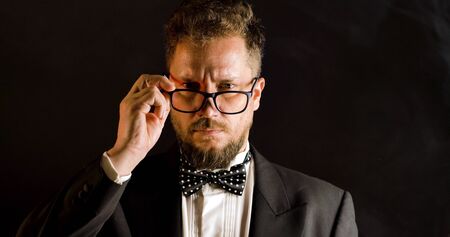 Handsome man in suit on black background. Portrait of elegance gentleman with glasses. Luxury lifestyle. Portrait of adult spy wearing trendy suit in studio.の写真素材