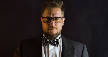 Handsome man in suit on black background. Portrait of elegance gentleman with glasses. Luxury lifestyle. Portrait of adult spy wearing trendy suit in studio.の写真素材
