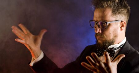 Emotional conductor on dark background. Man conducting an orchestra.の写真素材
