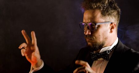 Emotional conductor on dark background. Man conducting an orchestra.の写真素材