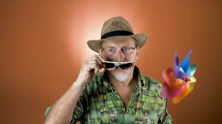 Studio portrait of the crazy grandfather on colored backgrounds. Peoples emotion. Happy and funny...