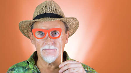 Studio portrait of the crazy grandfather on colored backgrounds. Peoples emotion. Happy and funny celebrating people.の写真素材