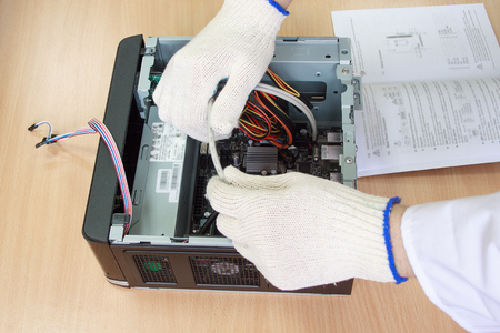 Electronics engineer making a personal computer. Instruction for assembly. Hands and accessories of closeup.の写真素材