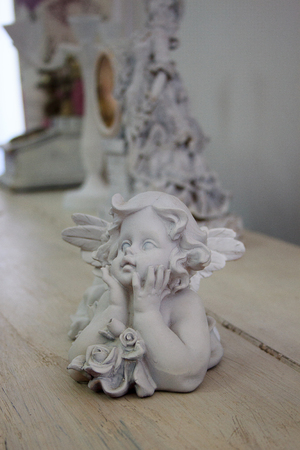 Old statuette of an angel on a wooden table.の写真素材