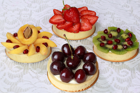 Appetizing tartlets with cherry, strawberry, apricot, kiwi and pomegranate. Sweet dishes.の写真素材