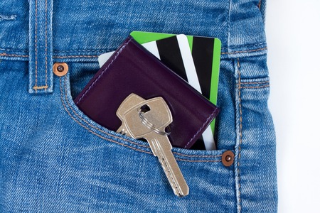 Wallet, credit cards and keys to the house on a keychain are lying in a side pocket of blue jeans.の写真素材