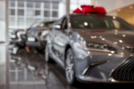 Car auto dealership. New cars at dealer showroom. Prestigious vehicles. Themed blur background with bokeh effect.の写真素材