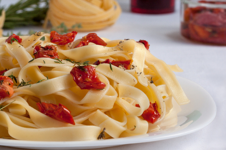 Fettuccine pasta with sun-dried tomatoes and fresh herbs. Close up. Healthy lifestyle.の写真素材