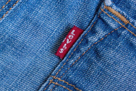 Russia, Izhevsk - May 17, 2018: The red tab on the back pocket of Levis jeans. Jeans stitches. World famous world brand Levi Strauss.のeditorial素材