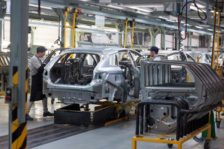 Russia, Izhevsk - December 15, 2018: LADA Automobile Plant Izhevsk, part of the AVTOVAZ Group. The workers put doors on the body of a new car. Modern car manufacturing enterprise.のeditorial素材
