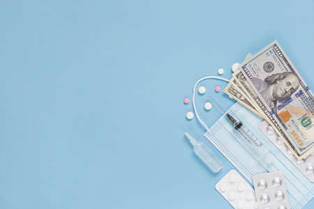 Medical face mask, packaging with pills, expendable syringe and paper money. The concept of insurance medicine, high cost of drugs.の写真素材