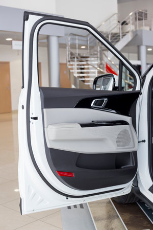 Russia, Izhevsk - February 17, 2022: KIA showroom. Interior of new modern Carnival crossvan car with opened driver door. Famous world brand. Modern transportation.のeditorial素材