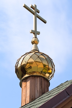 Gold cross with a dome against the dark blue skyの写真素材