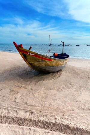 the lonely fishing boat on sand, in the eveningの写真素材