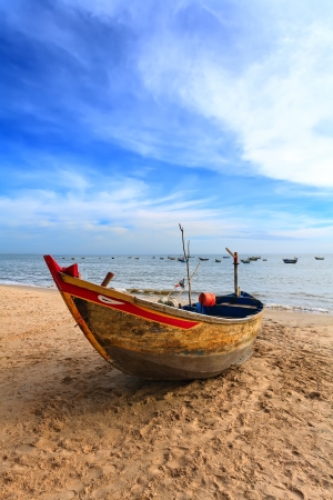 The wooden fishing boat on a sandy beach at the seaの写真素材