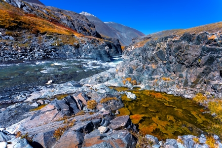 the fast river among black rocks and the stone desertの写真素材
