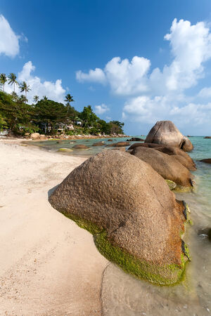 Tropical beach with granite boulders on sand and turquoise water.の写真素材