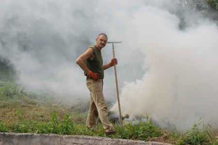 Man burn out dry grass in the garden.Ukraine の写真素材