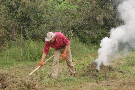 Man burn out dry grass in the garden.Ukraine の写真素材