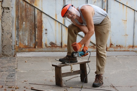 Man works with angular electric grinder. Ukraine