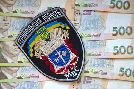 Kiev,Ukraine.Dec 14.Illustrative editorial.Ukrainian Police in Ternopol region.With money background. chevron .At December,2014 in Kiev, Ukraineのeditorial素材