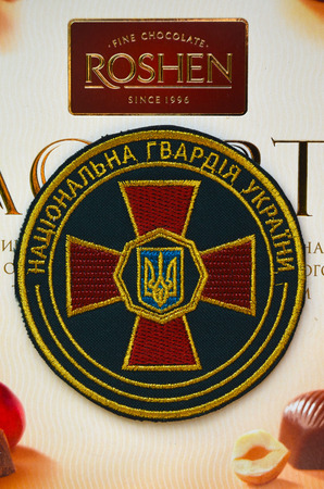Kiev,Ukraine.Dec 20.Illustrative editorial.Chevron of Ukrainian National Guard.With logo Roshen Inc. Trademark Roshen is property of ukrainian president Poroshenko.At December 20,2014 in Kiev, Ukraineのeditorial素材