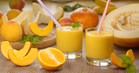 Melon banana Smoothie into a glass on the background of fresh fruits. The fruit cocktail is ready to eat. Healthy and vegetarian food concept.の写真素材