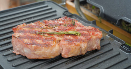 Delicious juicy beef steak with rosemary is cooked on an electric grill. Aged prime rare roast grilling tenderloin fresh marble tenderness beef.の写真素材