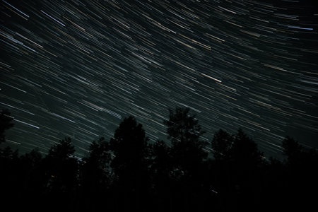 Long exposure captures the movement of stars, creating beautiful trails across the night sky above a...
