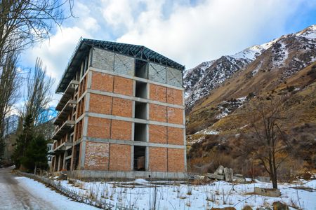 Unfinished big house at peak mountains foot. Brick wall.のeditorial素材