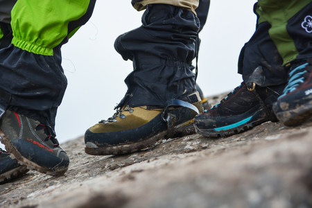 Side View of feet wearing hiking shoes with stone in background. Tourism concept. Selective focus.の写真素材
