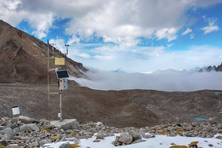 Weather station in mountains. Rocks, snow and stones in mountain valley view. Mountain panorama.の写真素材
